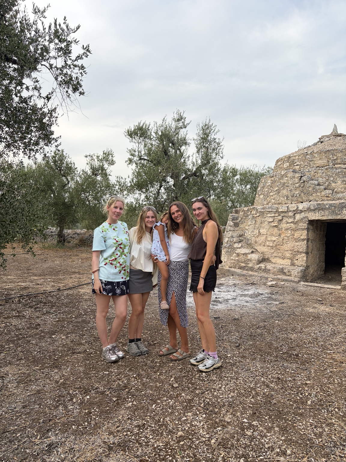 Visitors beside the Trullo in the grove